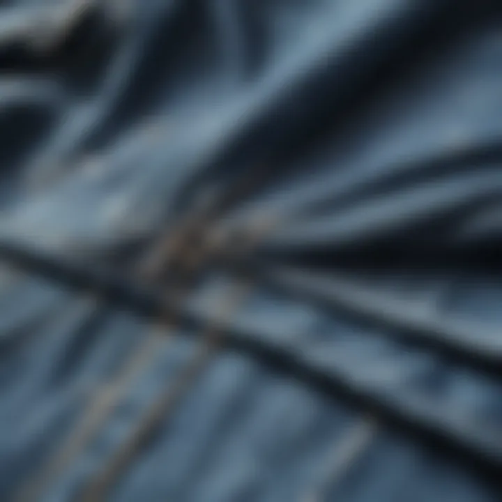 Close-up of the fabric texture and ripped details of a denim shirt.